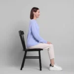 Vestibular Exercises for Vertigo: A Beginner's Guide. Woman sitting in a chair practicing gentle head-turn exercises for vertigo and balance rehabilitation.